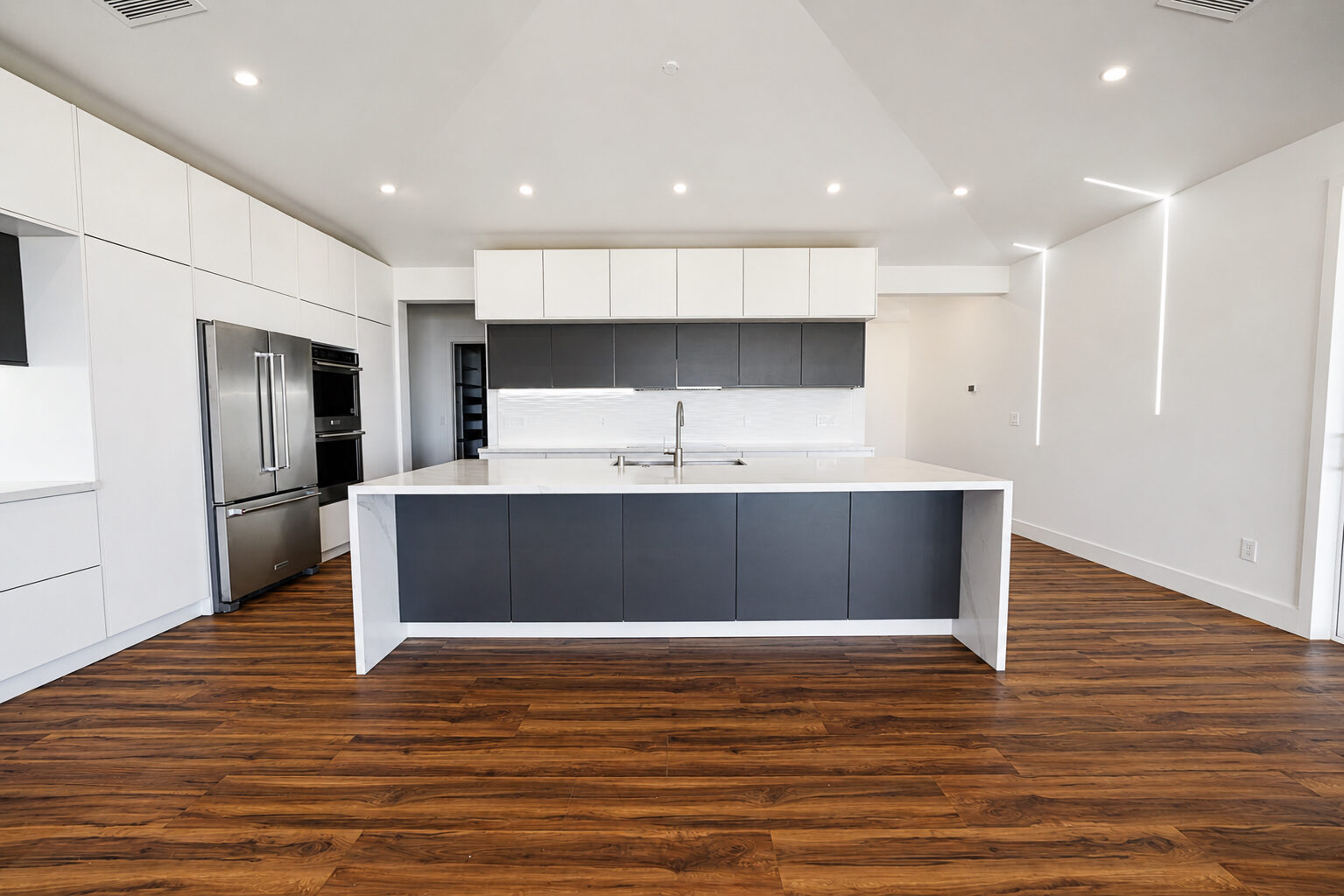 Kitchen with quartz waterfall island under a vaulted ceiling