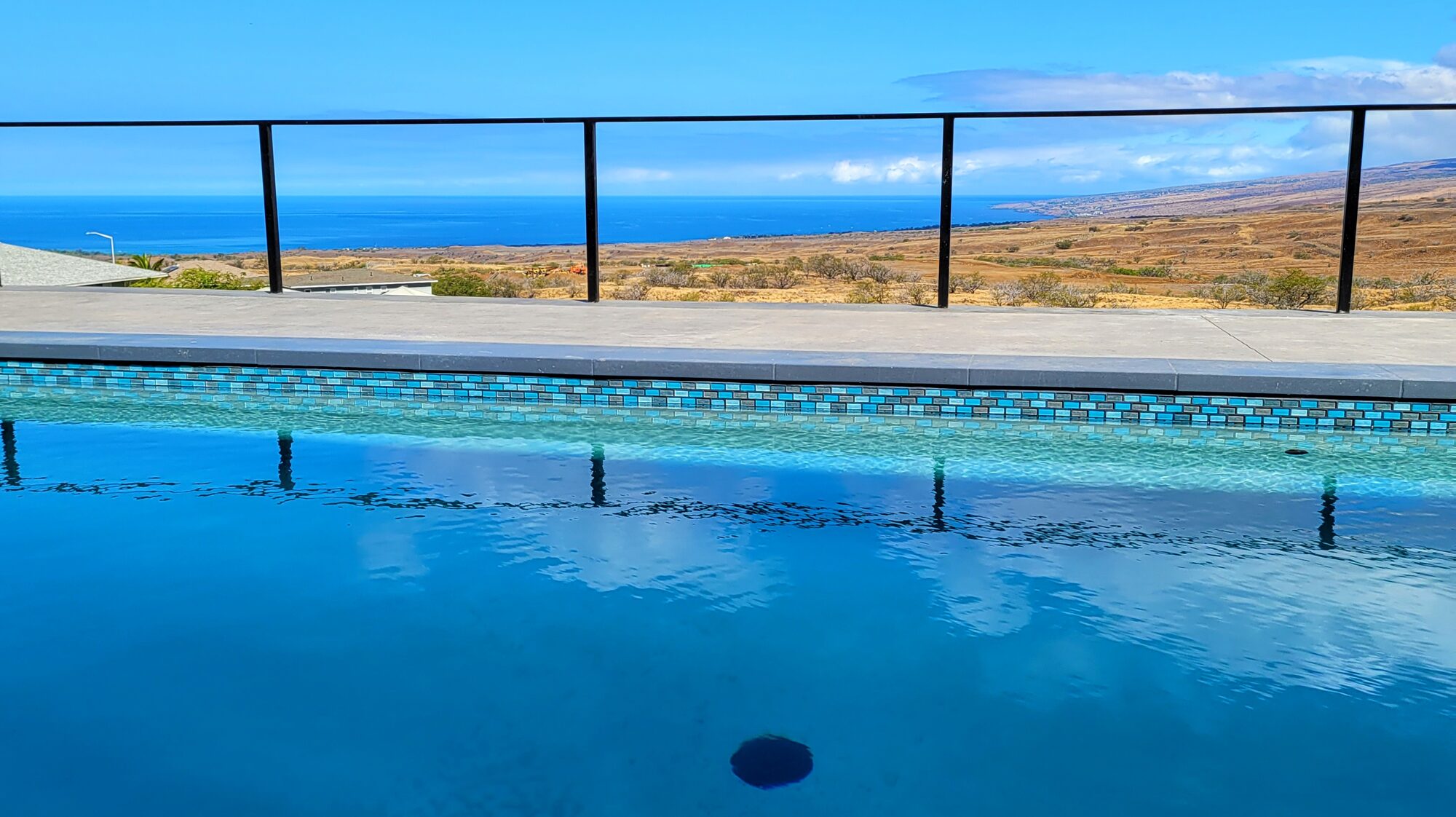 Pool with blue-tile edge and ocean view